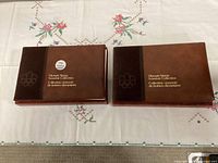 Two brown Olympic Stamp Souvenir Collection books in slipcases closed