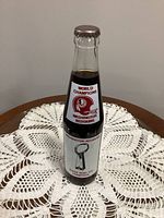 Front view of unopened Coca-Cola Redskins Super Bowl XVII Champions bottle showing logo and trophy graphic