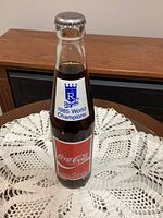 Front view of sealed 10oz Coca-Cola bottle with red label
