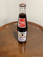 Front of sealed 10-oz Coca-Cola bottle with 50th anniversary Redskins label