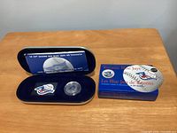 Open presentation case showing stamp and medallion with outer sleeve