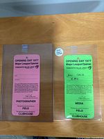 Fronts of pink Photographer and green Media passes showing event text and Lou Cauz inscription