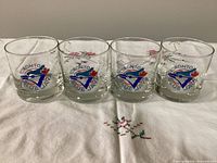 Front view of all four Blue Jays logo glasses on tablecloth
