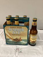 Six Samuel Adams Summer Ale empty bottles and carrier displayed on table