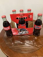 Front view of six unopened Grey Cup Coca-Cola bottles in carrier