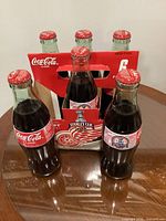 Front view of six unopened 2002 Detroit Red Wings Stanley Cup Coca-Cola bottles in cardboard carrier