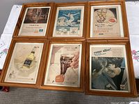 Six wood-framed vintage advertisements for Canadian beers, Coca-Cola and Pepsi