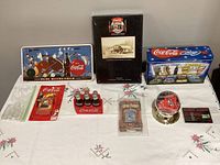 Overall shot of all Coca-Cola memorabilia items on table