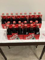 Four six-pack carriers holding sealed Coca-Cola Canadian Cities bottles