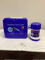 Front of blue lunch box showing Toronto Blue Jays and Neilson Dairy graphics with matching thermos