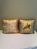 Front view of both Atelier Versace pillows showing designs and fringe
