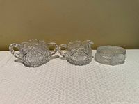 Front view of creamer, sugar bowl, and lidded dish side by side