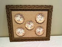 Full view of framed display showing five plates