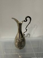 Full view of silver ewer showing shape and repoussé floral design