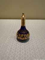 Full front view of cobalt and gilt porcelain scent bottle with stopper