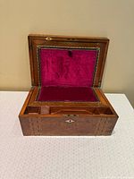 Writing slope open showing red velvet surface and interior compartments