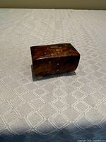 Front three-quarter view showing tortoiseshell veneer, silver studs and feet