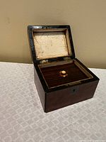 Tea caddy open showing inner compartment with sliding lid and knob