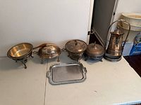 All six silver-plated items lined on table
