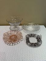 Four glass serving pieces arranged on table
