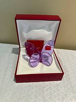 Peony color crystal butterfly inside open red Baccarat box with card