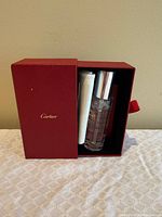 Open box showing lotion bottle, cloth and brush