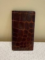 front view of brown crocodile-pattern leather wallet standing upright