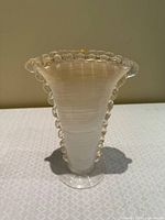 Front view of clear glass vase with white spiral body and beaded scalloped rim