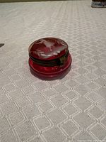 closed cranberry glass powder pot on table