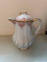 Front/side view showing porcelain teapot, floral decoration, gilt trim
