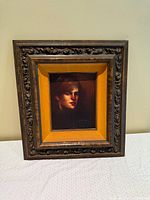 Full view of framed oil portrait on table