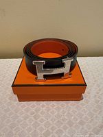 Belt rolled on top of Hermès box, H buckle visible