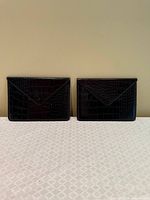 Front view of both black leather clutches side by side