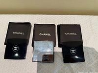 Three Chanel compact mirrors with pouches front view
