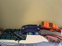 Overview of all five folded throw blankets on table