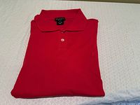 Folded red Gucci polo showing collar, label, and button