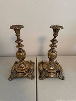 Front view of both candlesticks showing overall form and wear