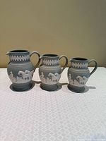 Front view of all three graduated Dudson jasperware jugs