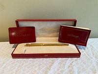 Pen displayed in open red presentation case with booklet and guarantee card