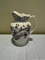 Full view of pitcher left side showing floral pattern and scalloped rim