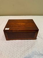 Front view of mahogany jewelry box showing oval inlay and beveled edges