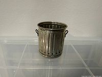 Front view showing ribbed body, handles, sterling sheen