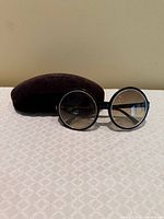 Front view of Tom Ford Carrie TF 268 sunglasses with case behind