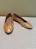 Top view of both beige Chanel ballet flats showing bow and CC logo