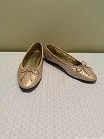 Pair of beige quilted Chanel ballet flats angled view