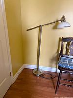 Full view of chrome floor lamp beside chair