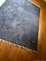 Full view of blue grey wool rug with fringe