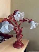 Full view of lamp showing red metal structure and three white fluted shades