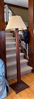 Full view of mahogany floor lamp beside staircase