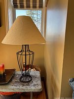 Lamp with cone shade on side table, showing full profile